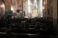 Wnętrzne kościoła w Chorzelowie. Uczestniczy mszy świętej siedząc w ławkach słuchają przemawiającego proboszcza.