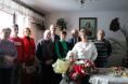 10 osób pozuje do zdjęcia, na pierwszym planie Pani Agnieszka Kasprzak na siedząco z bukietami kwiatów, za nią 9 osób na stojąco.