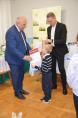 Wójt Józef Piątek i dyrektor Damian Małek wręczający małemu chłopcu dyplom i nagrody