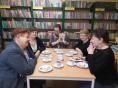 5 kobiet siedzi przy stole w bibliotece 